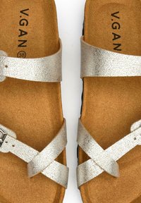Silver vegan sandals with two wide, crisscrossing straps; soft brown insole; size 38; textured straps and a flat black outsole.