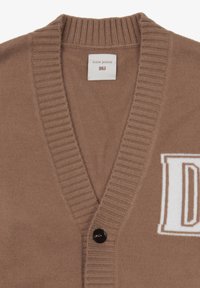 Brun cardigan med V-hals, ribbet krave og en sort knap. Har hvidt "DNJ" logo foran i et kontrasterende design.