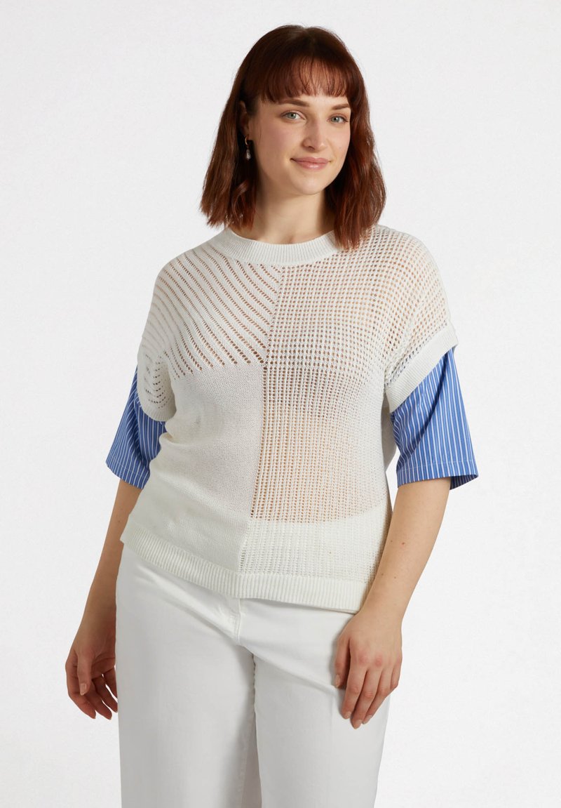 Sweter z dzianiny w białym i niebieskim kolorze, z siatkowym wzorem, krótkimi rękawami i luźnym krojem. Materiał jest lekki z teksturowanym wykończeniem.