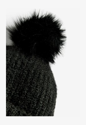 Čierna pletená čiapka s jemným, textúrovaným povrchom a nadýchaným čiernym brmbolcom na vrchu. Detailný pohľad zdôrazňujúci materiál a dizajn.