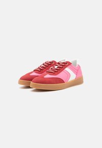 Zapatillas rojas y rosas con acentos blancos, material de ante, puntera redonda, suela plana de goma y cordones de múltiples tonos. Detalle de diseño retro visible.