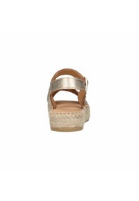 Sandalen met een metalen gouden bandjes bovenkant en een geweven jute platformzool. Het ontwerp heeft een verstelbare gesp voor een veilige pasvorm.