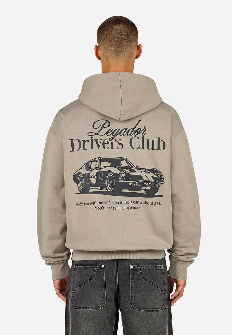Felpa beige con cappuccio regolabile, caratterizzata da una grafica nera di un'auto d'epoca e la scritta "Pegador Driver's Club" sulla schiena.