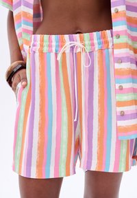 Multicolore, gestreepte shorts met levendige oranje, roze, groene, paarse en blauwe tinten, voorzien van een elastische tailleband en een trekkoord.