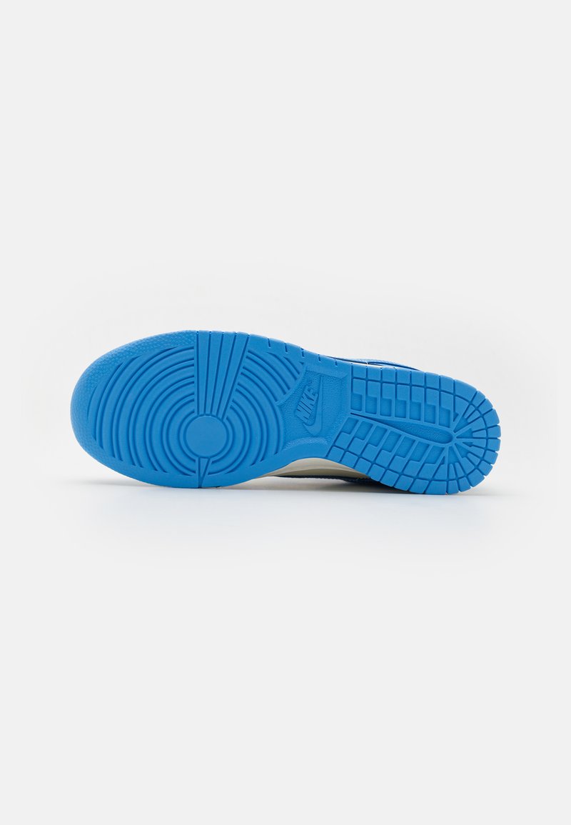 Suela de zapatilla Nike, que presenta una superficie de goma azul texturizada con patrones circulares y lineales, diseñada para ofrecer tracción y agarre.