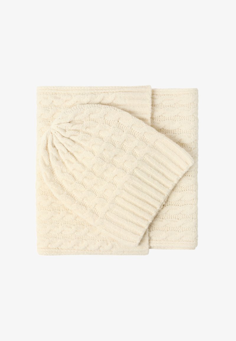 Conjunto de bufanda y gorro de punto en crema, con un patrón de trenzas texturizadas y bordes acanalados, hecho de un material suave y grueso.