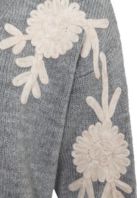 Grey knitted sweater featuring large, beige floral embroidery on the sleeve, with raised texture and symmetrical leaf designs.