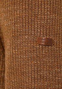 Brauner gestrickter Pullover mit vertikaler Rippstruktur. Enthält ein aufgenähtes Lederetikett mit der Aufschrift "Authentic Clothing Redmond."