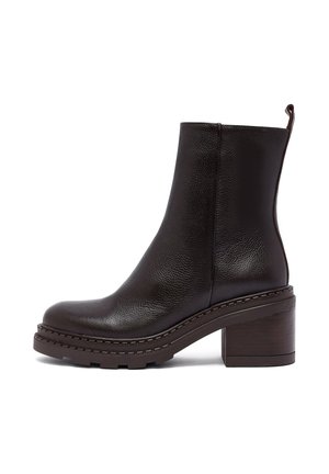 Bottine en cuir noir avec semelle épaisse crantée, talon bloc et languette à l'arrière, vue de côté extérieur sur fond blanc.