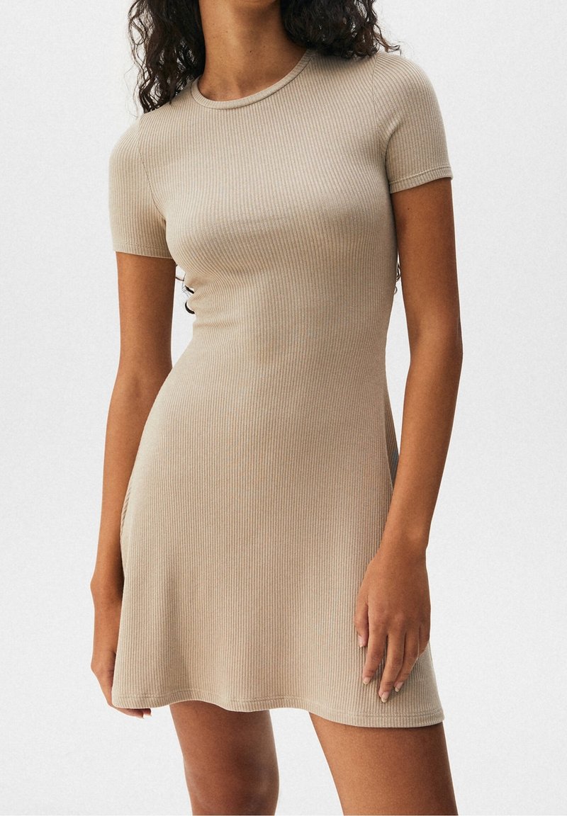 Abito beige a costine con maniche corte, design aderente e dettagli laterali. Tessuto liscio con una leggera elasticità per il massimo comfort.