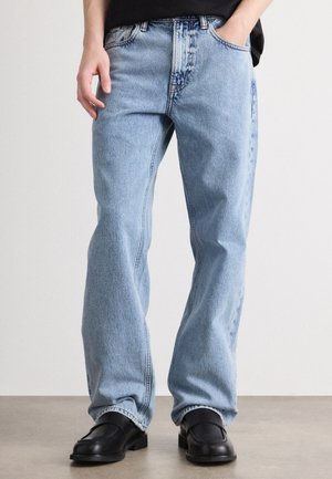 Jeans in denim blu chiaro con vestibilità comoda, dotati di cinque tasche e classica chiusura con zipper. Il tessuto presenta una leggera consistenza e una sfumatura.
