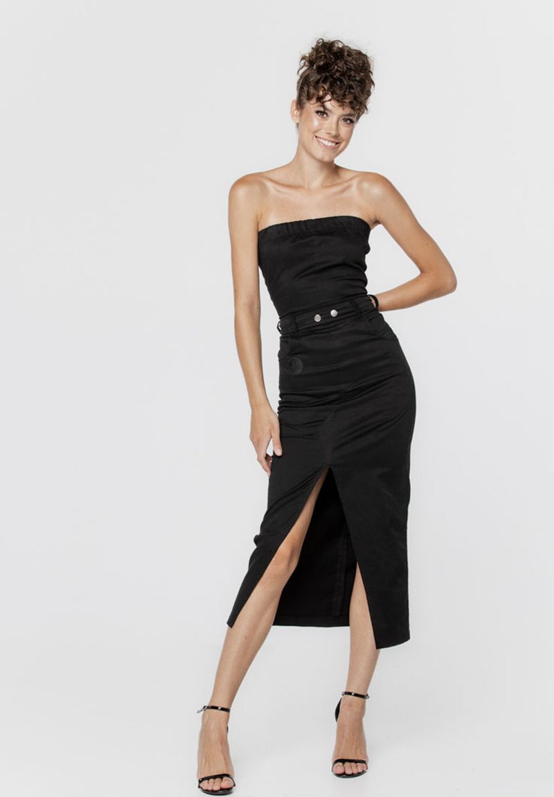 Czarna sukienka bez ramiączek o dopasowanej górze i wysokim rozcięciu, wykonana z gładkiego materiału. Posiada pasek w talii oraz dwa dekoracyjne guziki.