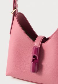 Vaaleanpunainen nahkakäsilaukku, jossa on teksturoitu pinta, ja jossa on kiiltävä violetti solki ja kaareva siluetti. Hihna kiinnitetty kultaisen silmukan avulla.