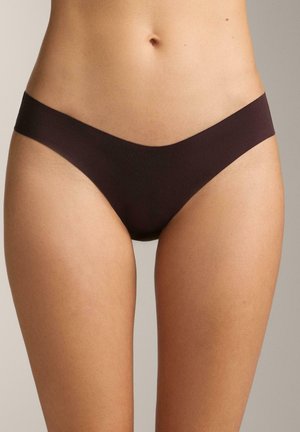 Torso feminin purtând lenjerie de corp tip bikini de culoare maro închis, pe un fundal neutru.