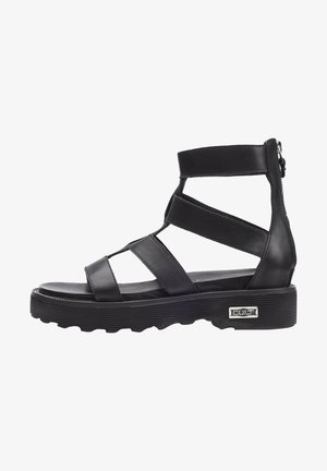 Sandali in pelle nera con molte cinghie incrociate, suola spessa e zip laterale, caratterizzati da un motivo testurizzato e un accento con logo argentato.