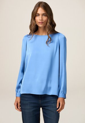 Blusa di raso azzurro chiaro con scollatura quadrata, maniche lunghe a palloncino e vestibilità rilassata. Texture liscia e dettagli di design minimalisti.