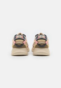 Béžové sportovní boty s růžovými a tmavě modrými akcenty, síťovanými panely, polstrovanými límci a texturovanými podrážkami. Výrazný prvek značky na zadní straně.
