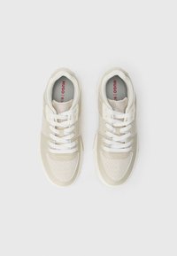 Sneakers with cream synthetic material, white laces, textured panels, and a subtle logo pattern. Cushioned insoles in a light shade.