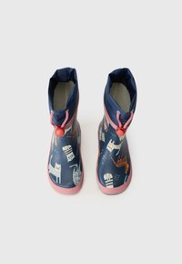 Botas de chuva de borracha azuis com solas cor-de-rosa, apresentando um padrão de vários gatos, e um colar ajustado com fecho tipo toggle.