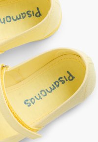 Gelbe Leinenschuhe mit abgerundetem Zehenbereich und Knöchelriemen. Im Inneren ist der Markenname "pistachios" in blauer Schrift zu sehen. Weicher Stofftextur.