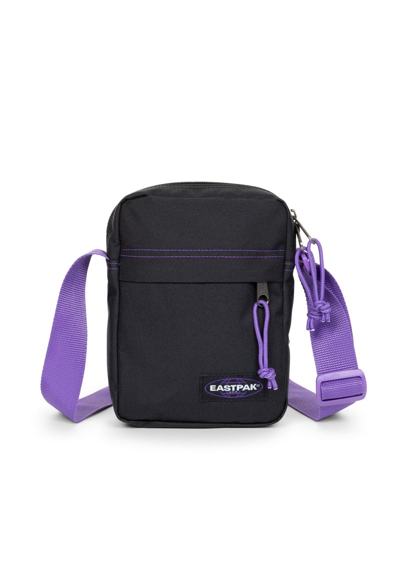 Sort stof crossbody tas med en lilla justerbar rem, der har en lynlåslukning, diskrete syninger og et Eastpak logo patch.