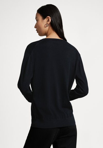 Black sweater with long sleeves and ribbed hem, featuring a crew neckline and a smooth texture. Viewed from the back.