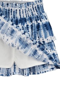 Fustă mini alb-albastră cu imprimeu tie-dye, cu un talie elastică, volane suprapuse și o țesătură texturată. Are un căptușeală interioară albă.