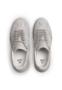Een paar lichtgrijze leren sneakers met veters, suède accenten en "LLOYD" branding op de tongen en binnenzolen, gezien van bovenaf op een witte achtergrond.