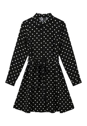 Robe-chemise noire à manches longues et à pois blancs, avec un col pointu, des boutons sur le devant et une ceinture à nouer, sur fond blanc.