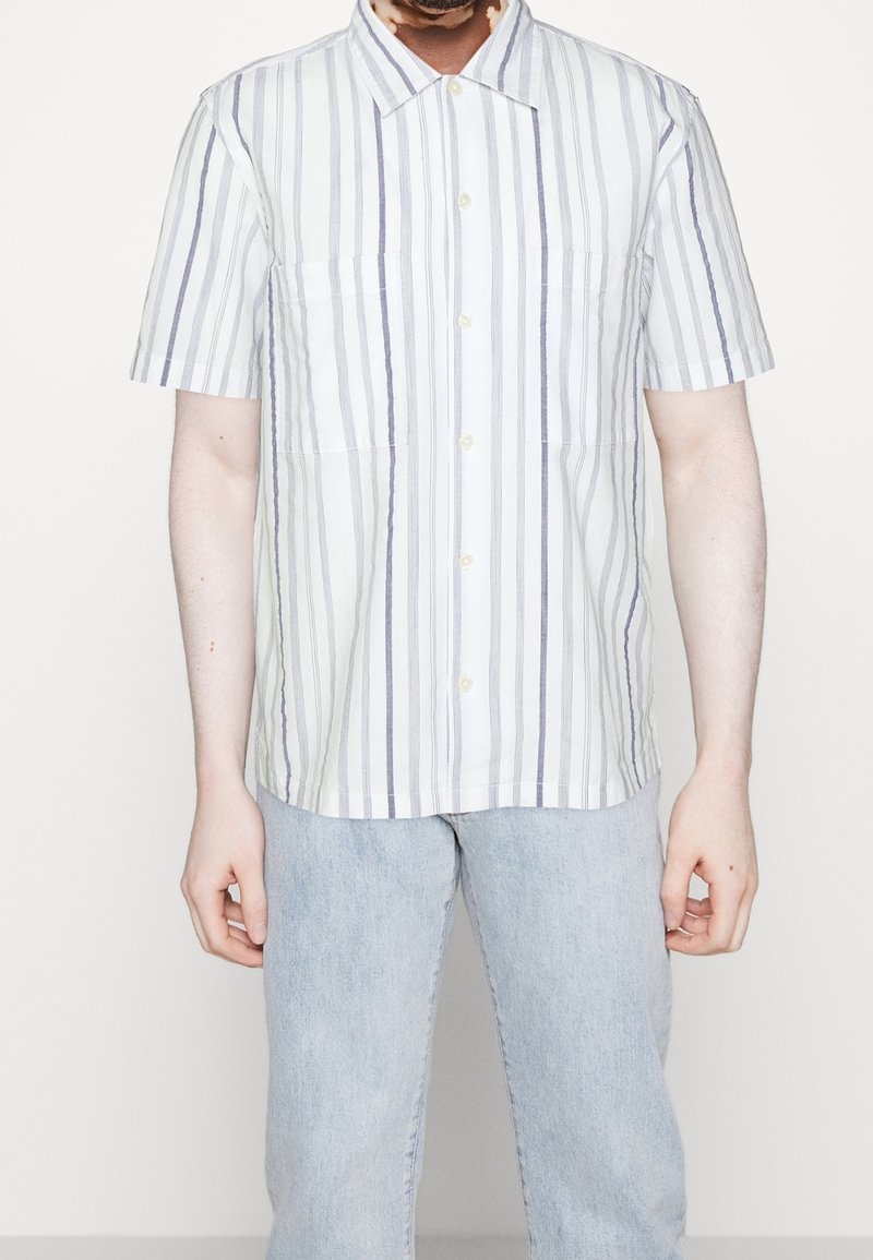 Camicia a maniche corte con strisce verticali blu e bianche, design con bottoni sul davanti, due tasche sul petto e una vestibilità rilassata.