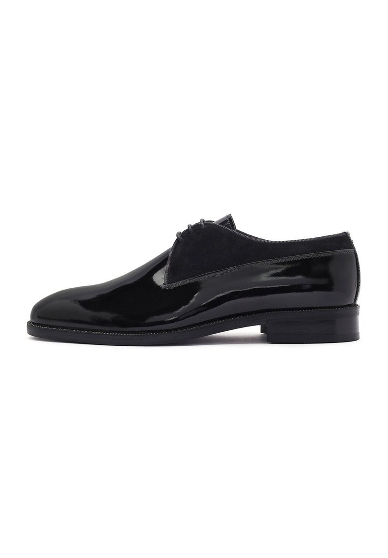 Chaussures en cuir verni noir avec une finition lisse, des accents en suede et un bout arrondi. Le design présente un petit talon empilé.