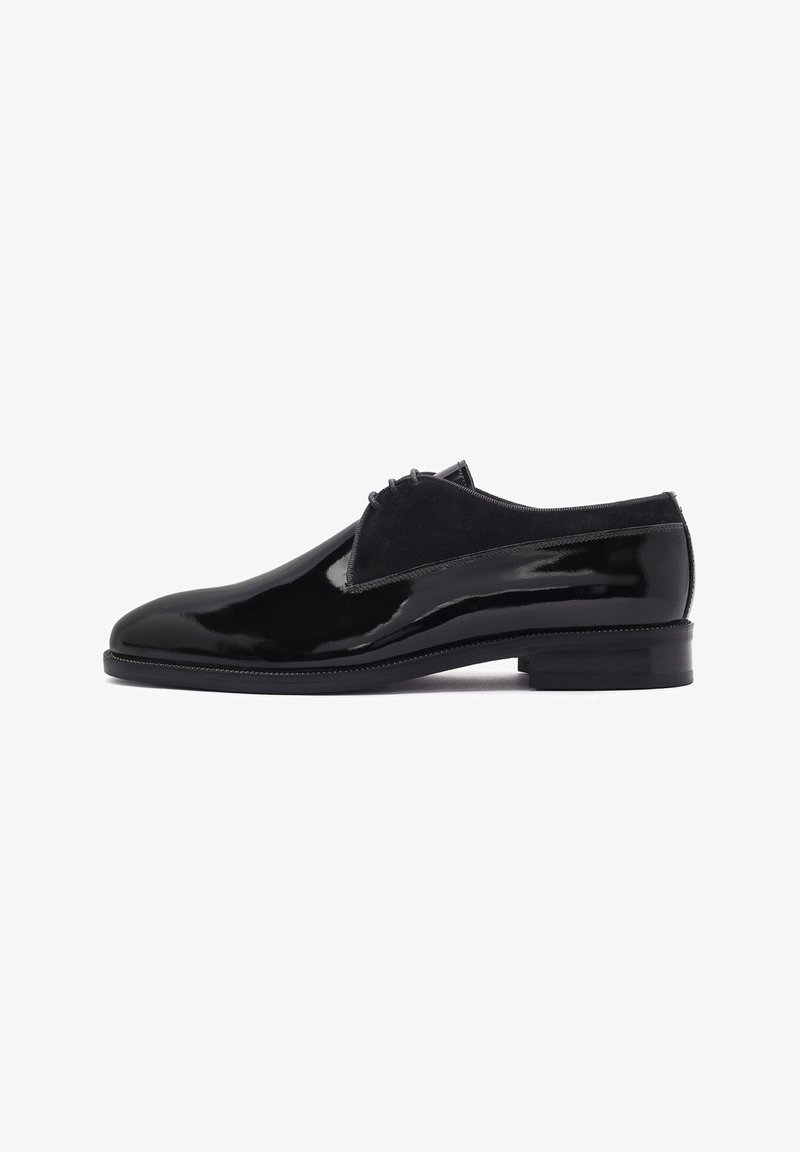 Chaussures en cuir verni noir avec une finition lisse, des accents en suede et un bout arrondi. Le design présente un petit talon empilé.