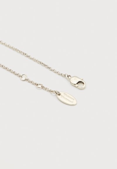 Ασημένιο κολιέ με αλυσίδα με κούμπωμα αστακού και οβάλ πλακέτα με το όνομα της μάρκας, τοποθετημένο σε λευκό φόντο.