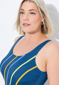 Jednodílné plavky v námořnické modré s vertikálními pruhy v světle modré, žluté a zelené barvě. Mají široké ramínka a kulatý výstřih.