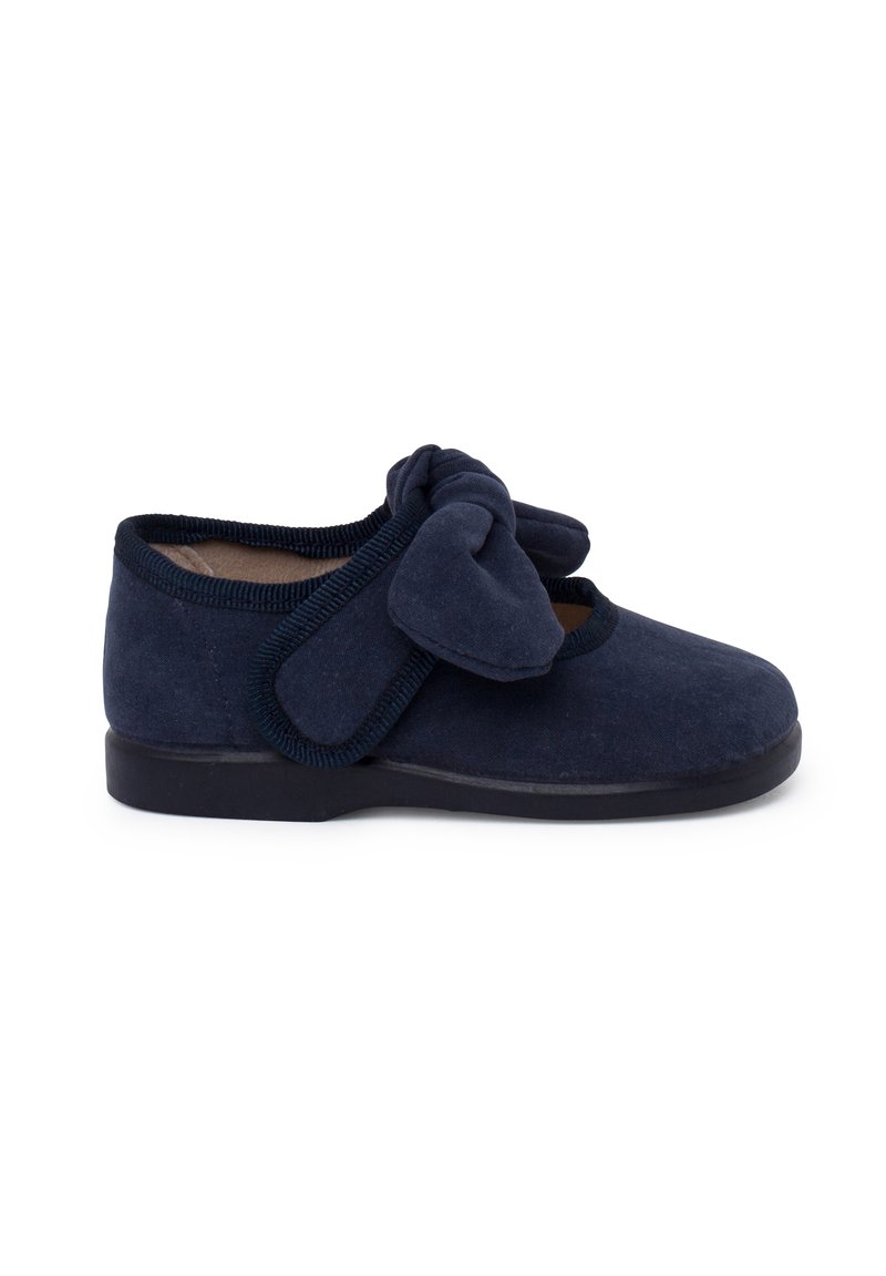 Scarpa in suede blu navy con punta arrotondata, bordino elasticizzato e un grande fiocco in tessuto sulla parte anteriore. Suola piatta in gomma.
