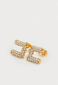 Boucles d'oreilles dorées en forme de lettres "Z" stylisées, ornées de strass transparents. Texture lisse avec un fermoir sécurisé.