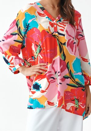 Farverig blomsterbluse med V-hals, knapdetaljer og flagrende ærmer. Fremstillet af let stof i levende nuancer af pink, rød og blå.