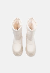 Botine albe impermeabile, până la glezne, cu o căptușeală moale și pufoasă. Include vârf rotunjit, guler căptușit și talpă texturată pentru aderență.