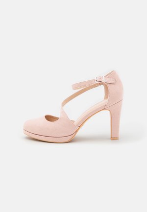 Scarpa con tacco alto in suede rosa, con punta arrotondata, design a taglio, cinturino alla caviglia con fibbia regolabile e suola piattaforma.