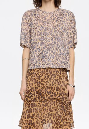 Leopardmønstret top med korte ærmer, lys stof, beige og brune nuancer. Kombineret med et matchende lagdelt leopardmønstret nederdel.