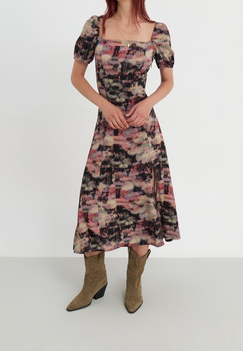 Midi-mekko, jossa on kukkakuosi, neliönmuotoinen pääntie, puffiset lyhyet hihnat ja virtaava hame, sävyissä vaaleanpunainen, vihreä ja musta.