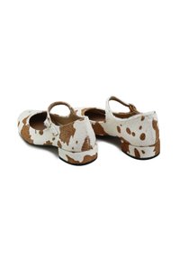 Zapatos Mary Jane con estampado de vaca y tacón bajo, que cuentan con una tela suave y texturizada y una correa decorativa sobre el empeine.