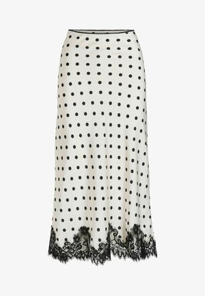 Jupe à pois crème avec des pois noirs, dotée d'un ourlet en dentelle noire festonné. Tissu lisse, coupe ajustée, longueur au genou.