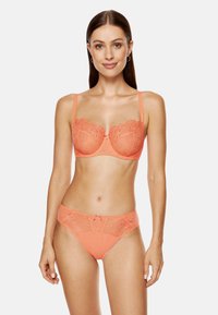 Koronkowy biustonosz w kolorze koralowym z fiszbinami, z kwiatowym wzorem i delikatnym detalem w postaci kokardki; dopasowane półprzezroczyste koralowe figi z koronkowymi akcentami.