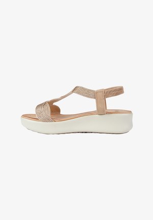 Sandalo beige da donna con cinturini intrecciati, cinturino posteriore elastico, sottopiede imbottito e suola platform bianca.