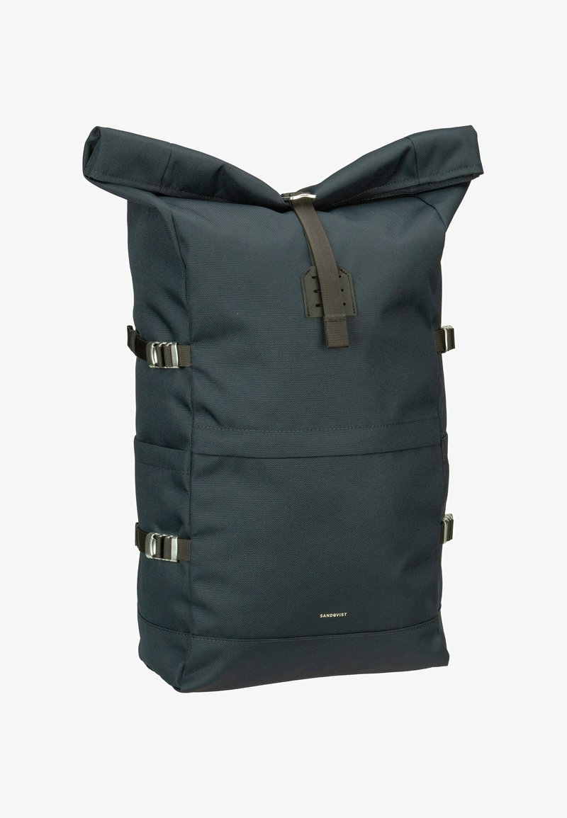 Mochila de tela negra con cierre tipo rollo, detalles en hardware plateado, dos correas laterales ajustables y una superficie texturizada.