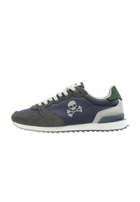 Baskets pour hommes avec une tige en tissu bleu marine, des accents en suède gris, une semelle intermédiaire blanche et un motif de skull et os croisés sur le côté. Onglet de talon vert.