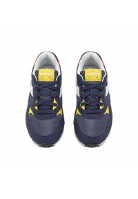 Sneaker marinari e bianchi con accenti gialli, dotati di una tomaia in tessuto testurizzato, punta arrotondata e design con lacci per una vestibilità regolabile.