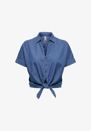 Camisa de mezclilla corta, azul con lunares blancos, de mangas cortas, cierre de botones, diseño con nudo en la parte delantera, textura suave, estilo casual.