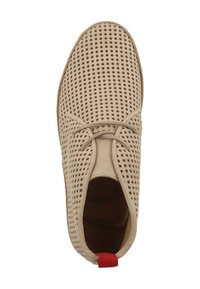 Scarpa beige in suede con design perforato, punta tonda, lacci piatti e un accento rosso sul tallone. Texture liscia, silhouette bassa.
